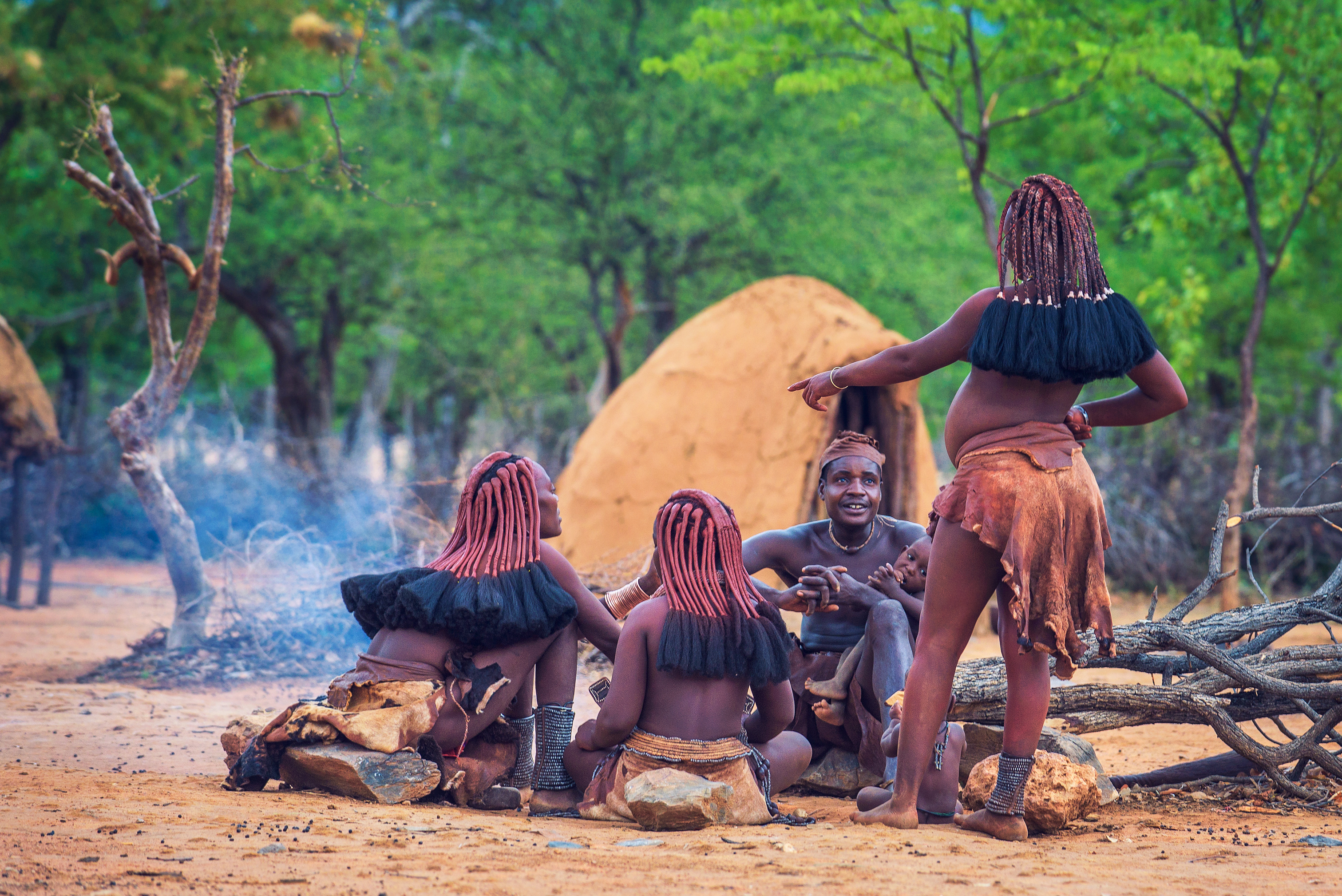 People Of The Himba Tribe Sitting Around Fire In Their Village